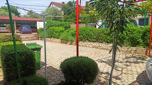 a garden with a tree and a red pole at App Sabolic in Umag