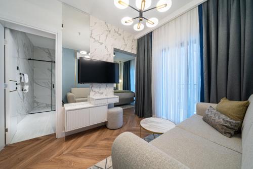 a living room with a couch and a tv at Hotel Millennium by Aycon in Budva