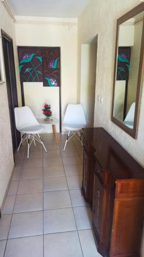 a room with two white chairs and a mirror at App Sabolic in Umag