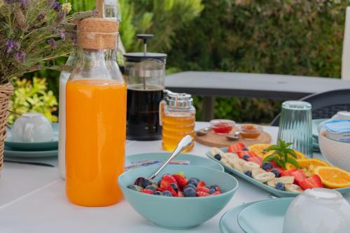 un tavolo con un cesto di frutta e una bottiglia di succo d'arancia di Monte Corte Enchária a São Teotónio