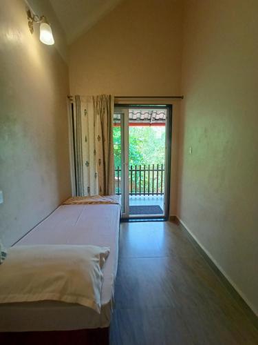 a bedroom with two beds and a sliding glass door at OmBodhi Retreat in Kumta