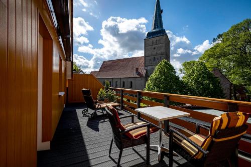 a balcony with a table and chairs and a church at Landhaus Wremer Deel in Wremen