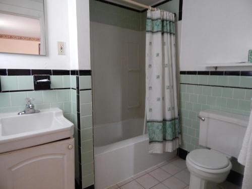a bathroom with a sink and a toilet and a shower at Knights Inn Centerville Cape Cod Area in Centerville