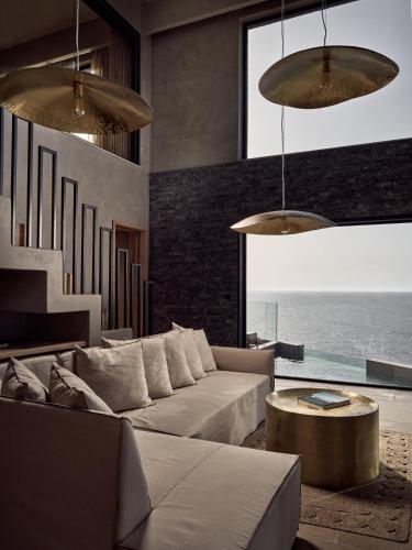 a living room with a couch and a table at Acro Suites - A Wellbeing Resort in Agia Pelagia