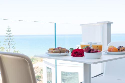 una mesa con comida y vistas al océano en Rodi Resort, en Rodi Garganico