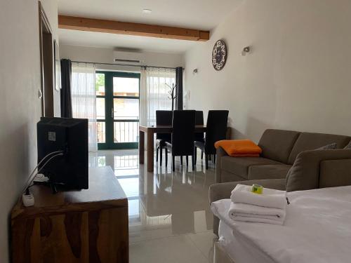 a living room with a couch and a table with chairs at Penzion Lednice in Lednice