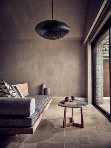 a living room with a couch and a table at Acro Suites - A Wellbeing Resort in Agia Pelagia