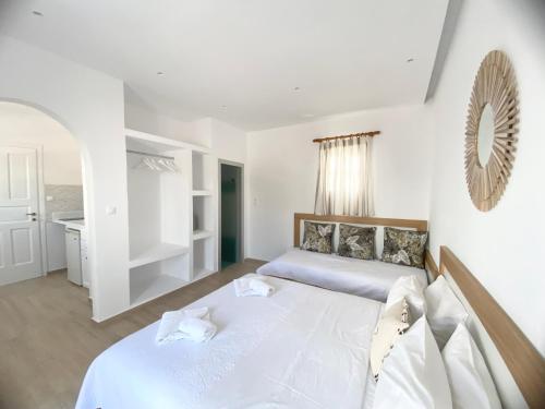 a bedroom with two beds and a mirror on the wall at Cyclades Blue in Ornos
