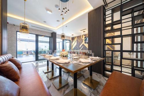 a dining room with a table and a couch at Hotel Millennium by Aycon in Budva