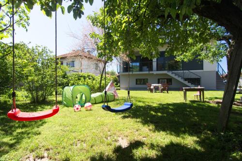 a playground with swings in the grass in a yard at Modern House in Visoko in Visoko