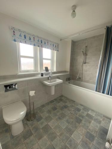 a bathroom with a toilet and a tub and a sink at The Lookout in Cellardyke