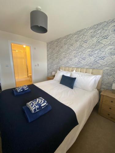 a bedroom with a large bed with two blue napkins on it at The Lookout in Cellardyke