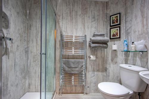 a bathroom with a toilet and a glass shower at Knap Guest House in Tarbert