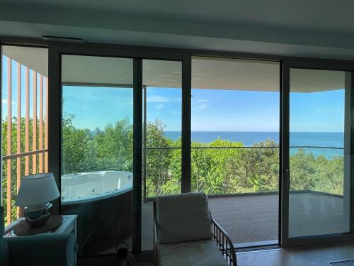 a bathroom with a tub and a view of the ocean at PINEA Apartments Pobierowo z niesamowitym widokiem na morze oraz jacuzzi w wybranych apartamentach in Pobierowo