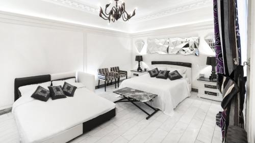 - une chambre blanche avec 2 lits et une table dans l'établissement The Paris Guest, à Paris