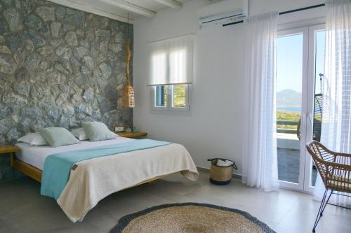 a bedroom with a bed and a stone wall at Hawk Stone in Adamantas