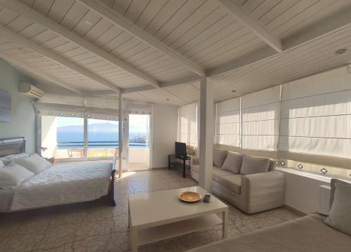 a bedroom with a bed and a couch and a table at Olympia Hotel in Sarandë