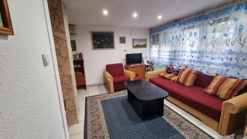 uma sala de estar com um sofá e uma televisão em Bianka vendégház em Berekfürdő