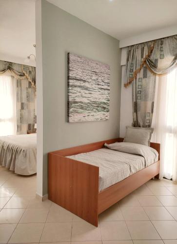 a bedroom with a bed with a wooden frame at Olympia Hotel in Sarandë