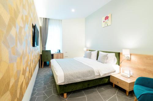 um quarto de hotel com uma cama e uma cadeira azul em Hotel Console em Slobozia
