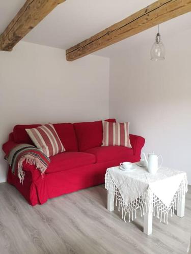a red couch in a living room with a table at Red Bed in Jankowice