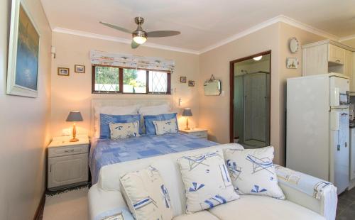 a bedroom with a bed with blue and white pillows at Dunwerkin Bachelor Flat in Kenton on Sea