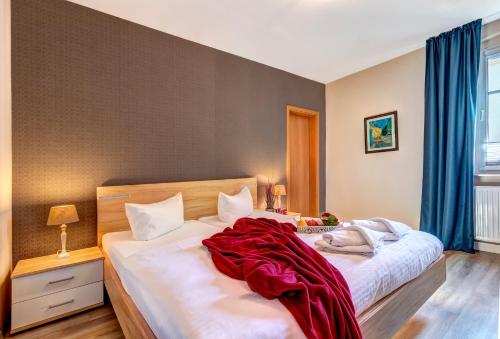 ein Schlafzimmer mit 2 Betten und einer roten Decke darauf in der Unterkunft Gartenoase Ahlbeck -01 in Ahlbeck