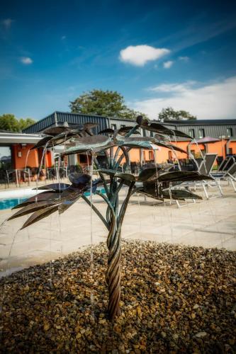 a sculpture of a tree in front of a pool at Le Noirlac in Saint-Amand-Montrond