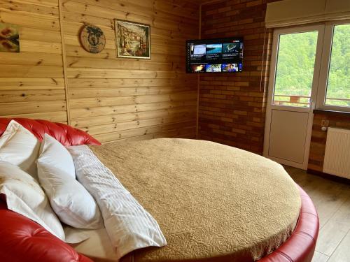 a bedroom with a bed with a tv on the wall at Готель Довбуш in Yaremche