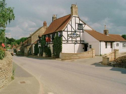 a building on the side of a street at The Blue Cow in South Witham