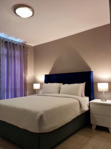 a bedroom with a large bed with two lamps at Island Club by Smart City Stays in Cape Town