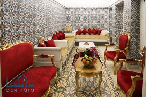 a living room with red chairs and a table at Dar Tata in Nabeul