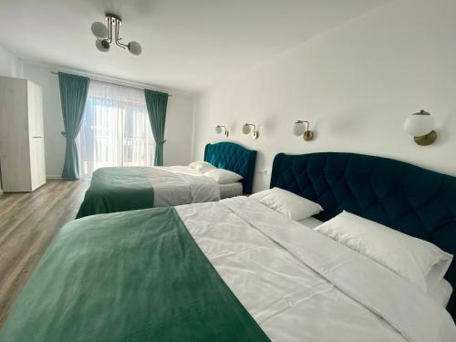 une chambre d'hôtel avec deux lits et un canapé dans l'établissement Alpin House Colibita, à Colibiţa