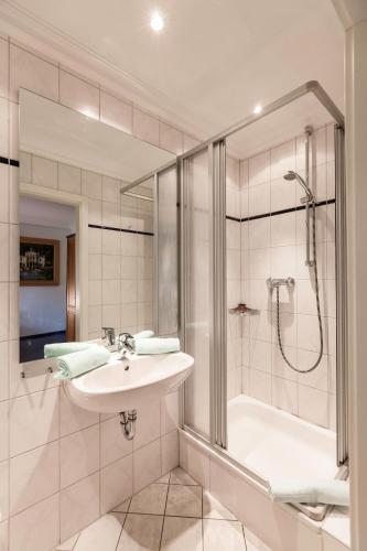 a bathroom with a sink and a shower at Schlossrestaurant Neuschwanstein in Hohenschwangau