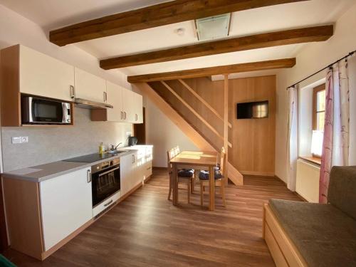 a kitchen with white appliances and a table in a room at Chata Kvilda in Kvilda
