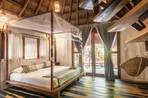 a bedroom with a canopy bed in a room at Eco Cabañas Laak Holbox - Adults Only - Self Check In in Holbox Island