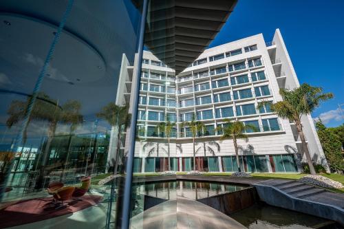 a building with a swimming pool in front of it at Lagoas Park Hotel in Oeiras