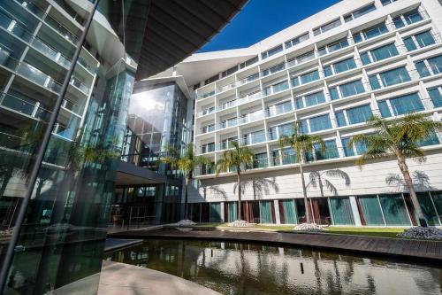 an office building with a pond in front of it at Lagoas Park Hotel in Oeiras