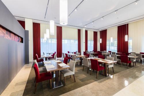 a restaurant with wooden tables and red chairs at Lagoas Park Hotel in Oeiras