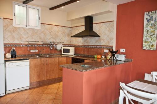 una cucina con pareti rosse e piano cottura forno superiore di Casa Rural Media Luna a Segorbe