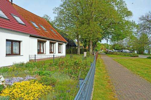 un jardín junto a una casa con una valla en schoene Ferienwohnung mit Terrasse, en Ralswiek