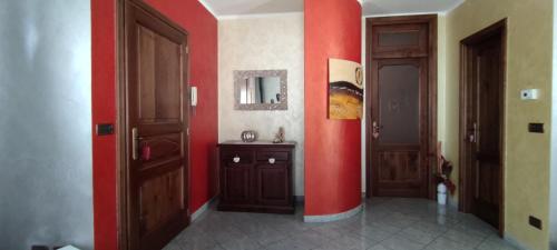 una stanza con due porte e una parete rossa di Chez Nicole a Verrès