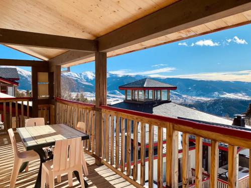 una terraza con mesa y sillas y vistas a las montañas en Font -Romeu : Beau T4 avec parking, terrasse et vue, en Font-Romeu-Odeillo-Via