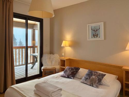 1 dormitorio con 1 cama y vistas a un balcón en Font -Romeu : Beau T4 avec parking, terrasse et vue, en Font-Romeu-Odeillo-Via