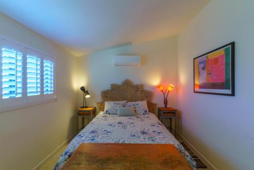 a bedroom with a bed with two tables and a window at Flying Point Homestead in Twentynine Palms