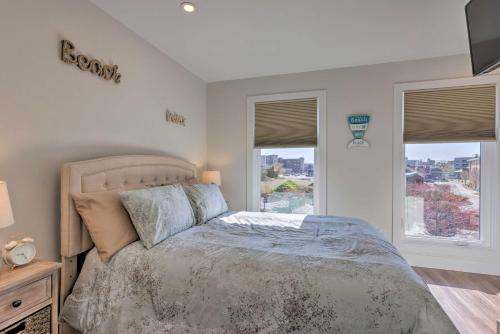 a bedroom with a bed and two windows at Traverse City Townhome Walk to Beach! in Traverse City