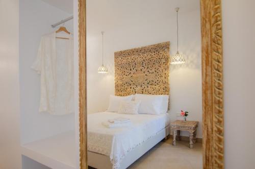 a bedroom with a mirror and a white bed at Youtopia Ios Villas in Ios Chora