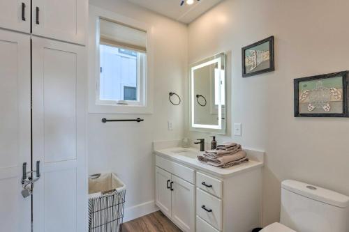 a white bathroom with a sink and a mirror at Traverse City Townhome Walk to Beach! in Traverse City