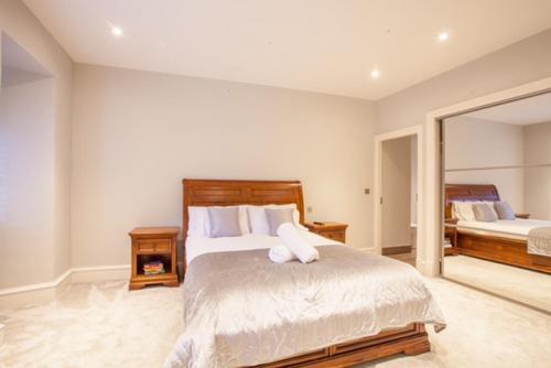- une chambre avec un grand lit et un miroir dans l'établissement Stylish 2 Bedroom Apartment In Park Circus, West End, à Glasgow