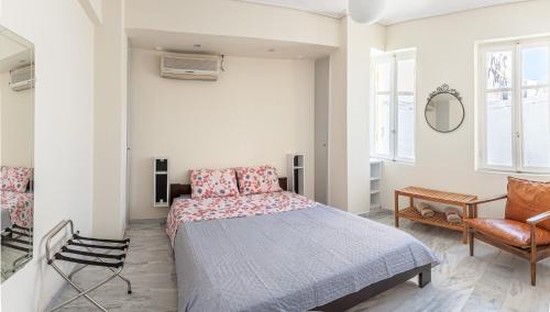 ein Schlafzimmer mit einem Bett und einem Stuhl in der Unterkunft Sunny apartment on the 2nd floor in bohemian Psiri in Athens' historic center-In Vivo Apartments in Athen